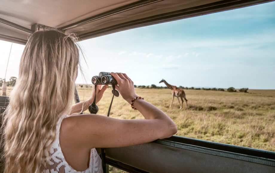 turista osserva giraffa dalla jeep nel masai mara